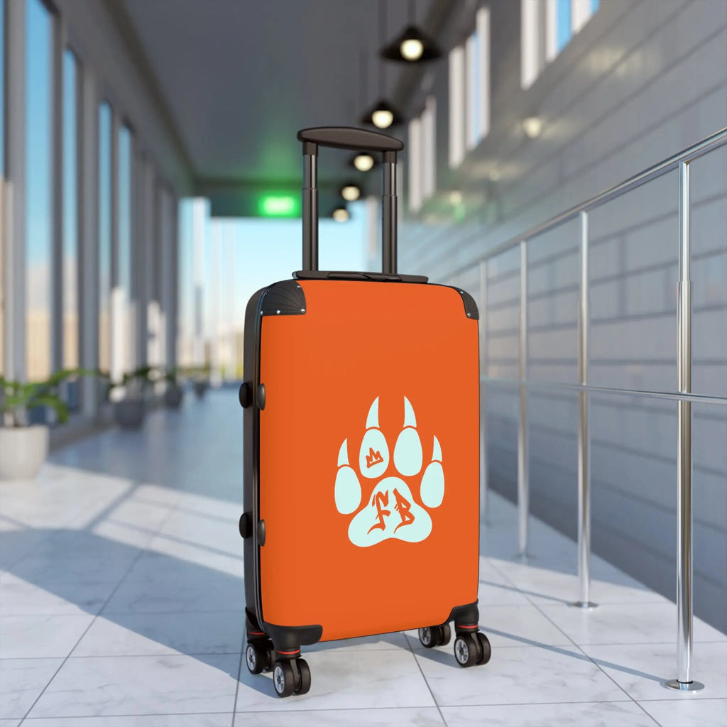 Orange hard-shell suitcase with black wheels and paw print design, perfect for travel and adventure.