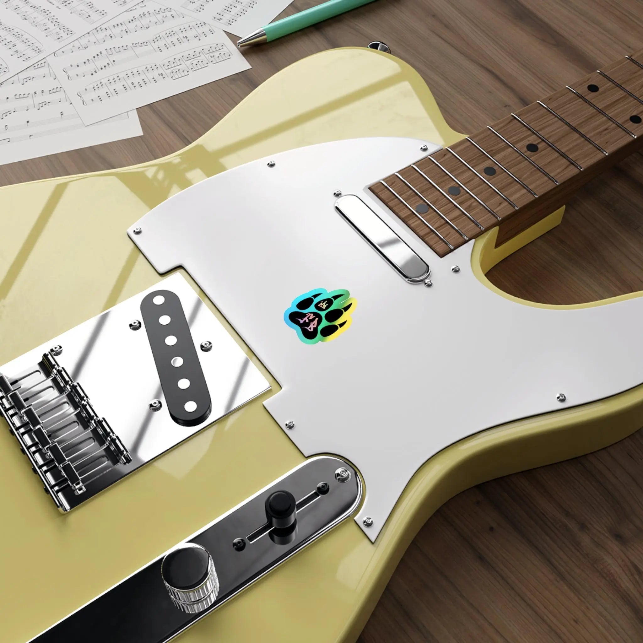 Yellow electric guitar with glossy finish, chrome hardware, and colorful graphic on white pickguard.