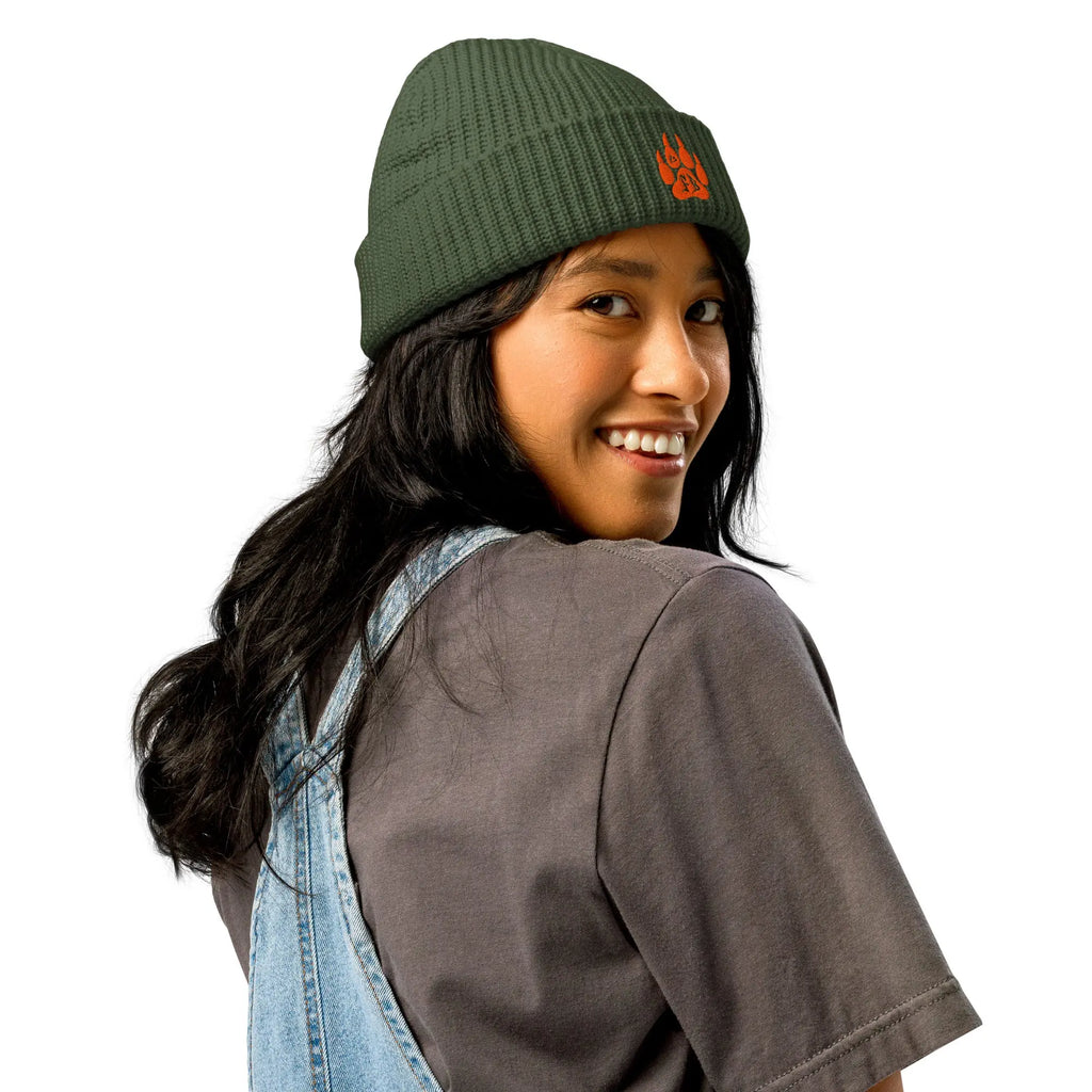 Olive green knit beanie with orange logo, worn by a smiling woman, ideal for casual style.