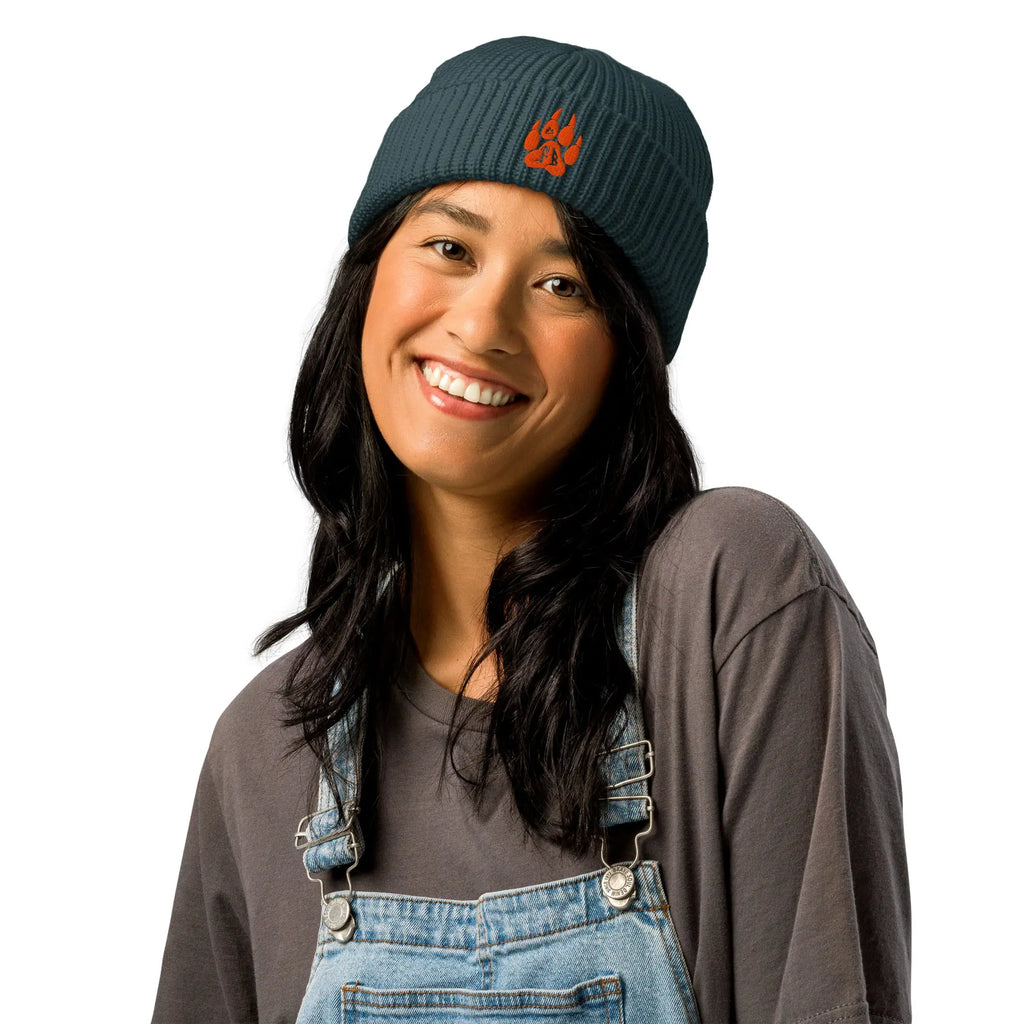 Women's dark teal ribbed beanie hat with orange logo, perfect for winter style and warmth.