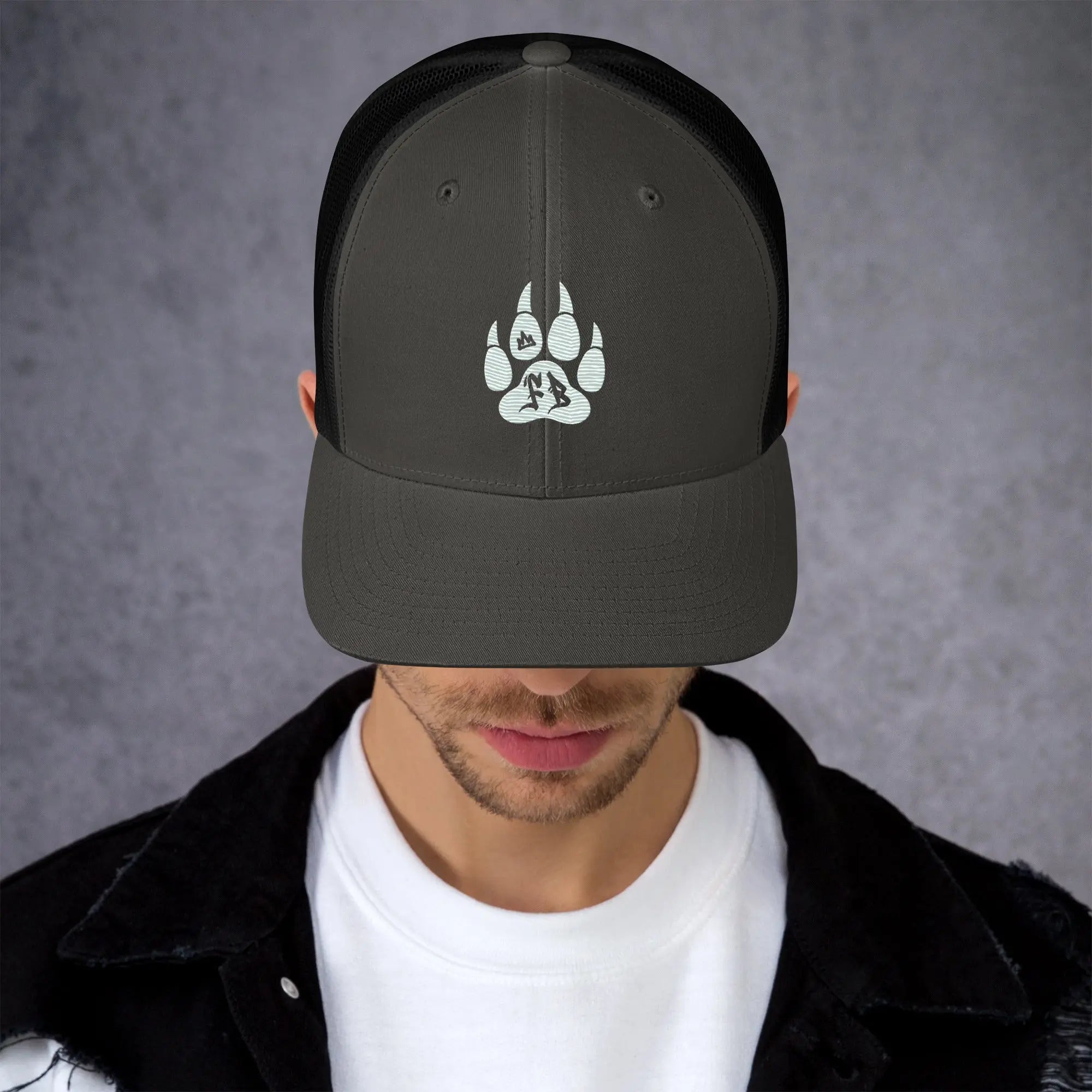 Stylish black mesh trucker cap featuring a white paw print design, perfect for outdoor enthusiasts.