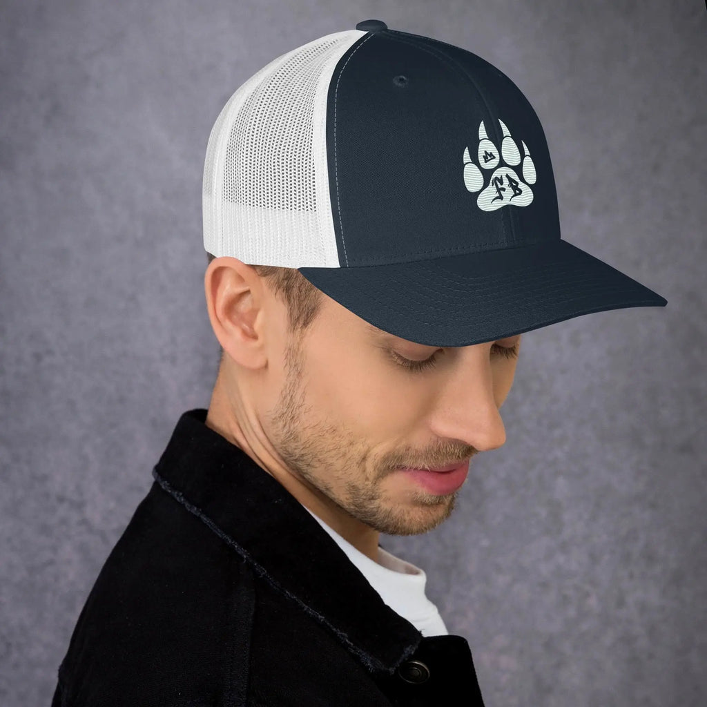 Men's navy blue and white mesh trucker hat with a stylish paw print design.