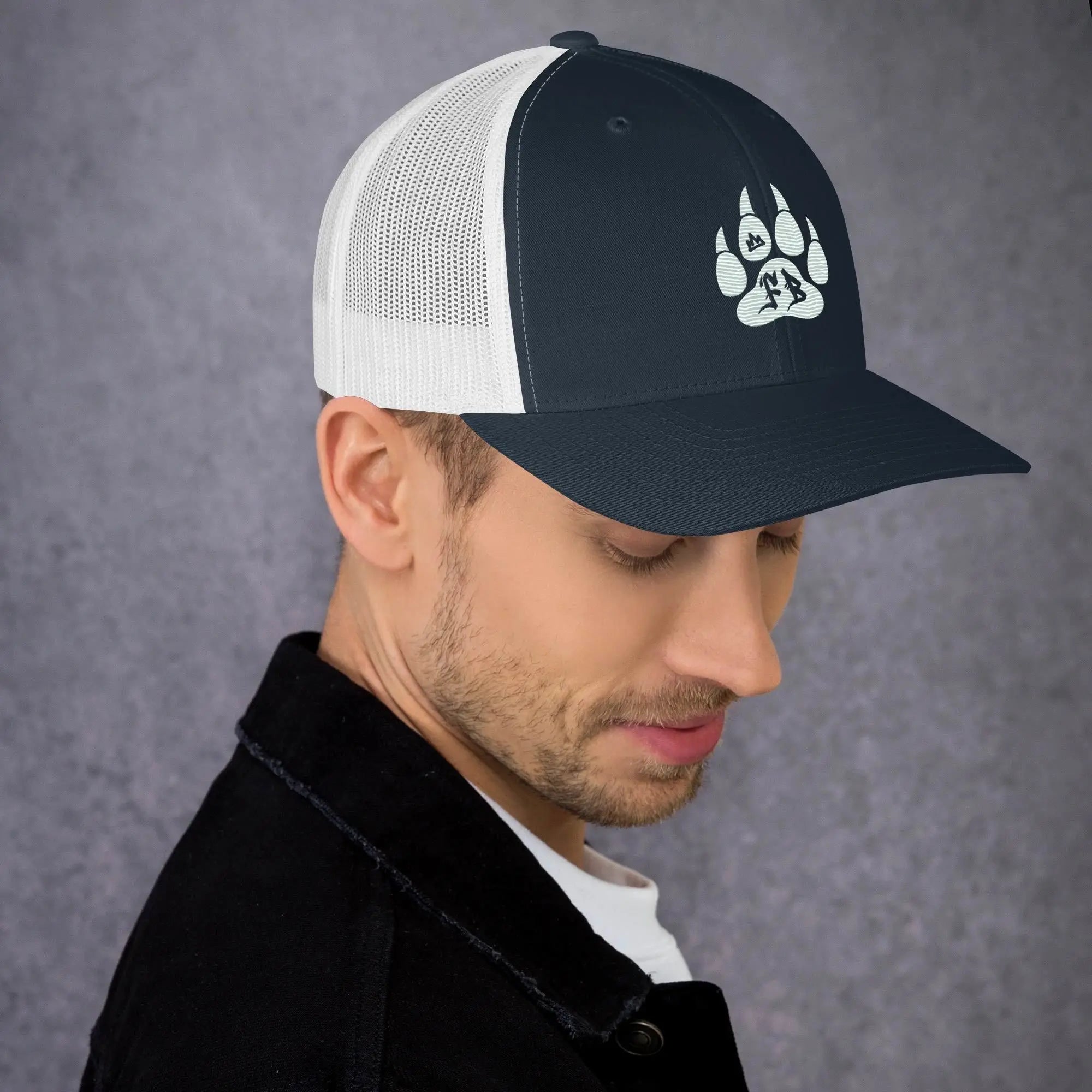 Men's navy blue and white mesh trucker hat with a stylish paw print design.